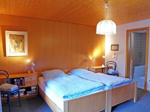 a bedroom with a large bed with a wooden wall at Holiday Home Chalet Marietta by Interhome in Kandersteg