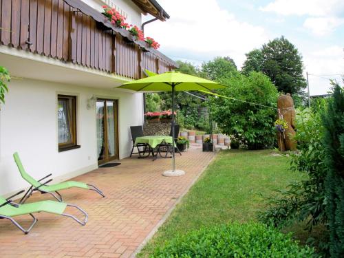 een patio met een parasol en een tafel en stoelen bij Apartment Alpenblick by Interhome in Brenden