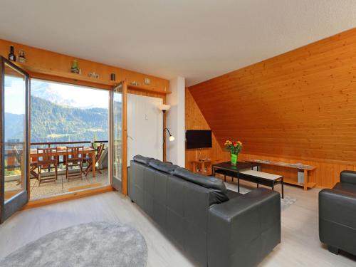 una sala de estar con un sofá y una mesa en Apartment Anémone 2-16 by Interhome, en Arveyes