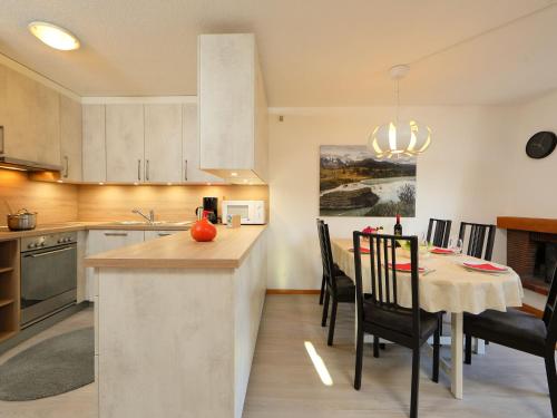 Una cocina y un comedor con mesa y sillas. en Apartment Anémone 2-16 by Interhome, en Arveyes