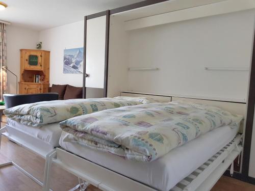 a bedroom with a white bed with a white headboard at Apartment Castor und Pollux-2 by Interhome in Täsch