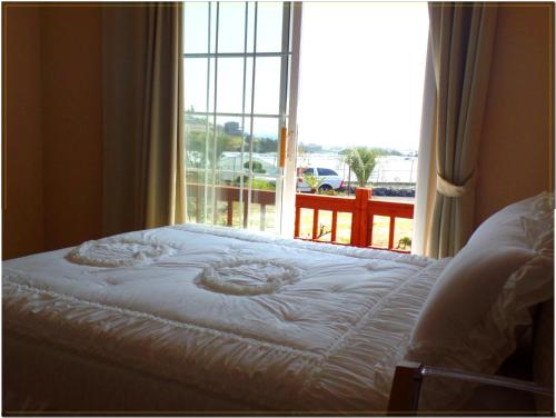 a bed in front of a window with a view at Jubilee Chalet in Seogwipo