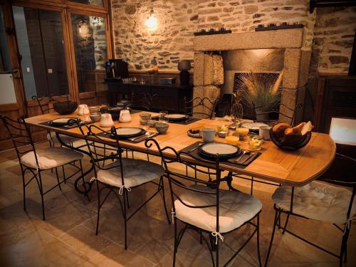 a large wooden table with chairs and a fireplace at L'AccrocheCoeur in Saint Malo