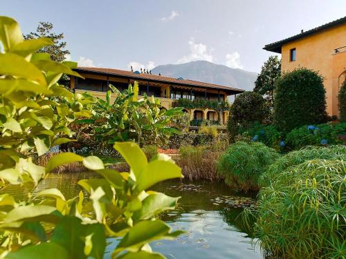 a house and a pond in front of a building at Apartment Giardino by Interhome in Ascona