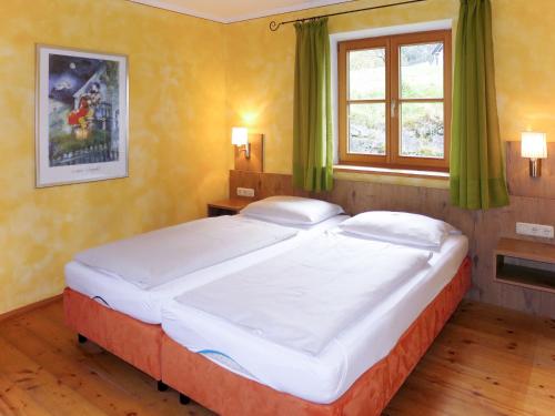 a large bed in a bedroom with green curtains at Holiday Home Maiergschwendt by Interhome in Ruhpolding