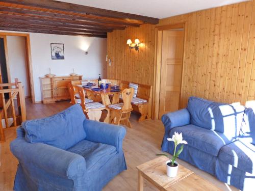 a living room with two blue couches and a table at Apartment Le Mont Blanc 2 by Interhome in Villars-sur-Ollon