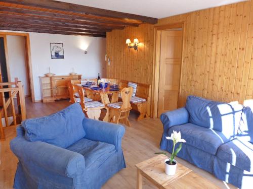 Apartment Le Mont Blanc 2 by Interhome في فيلار سور أولون: غرفة معيشة مع كنبتين زرقاوين وطاولة