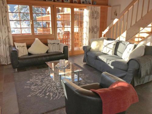 ein Wohnzimmer mit Sofas und einem Couchtisch in der Unterkunft Apartment Chalet Eiger-2 by Interhome in Grindelwald