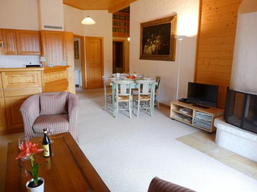 - un salon avec une télévision et une table avec des chaises dans l'établissement Apartment Le Faucon 7 by Interhome, à Villars-sur-Ollon