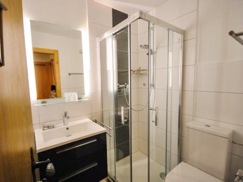 a bathroom with a glass shower and a sink at Apartment Les Bouillets by Interhome in Veysonnaz