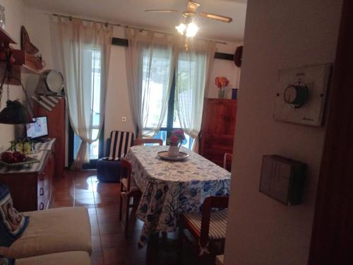 a living room with a table and a kitchen with curtains at RESIDENZA DI SANDRA in Isola Albarella