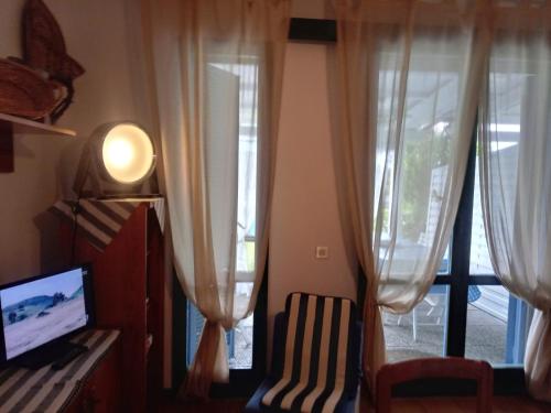 un salon avec une télévision et une fenêtre dans l'établissement RESIDENZA DI SANDRA, à Albarella