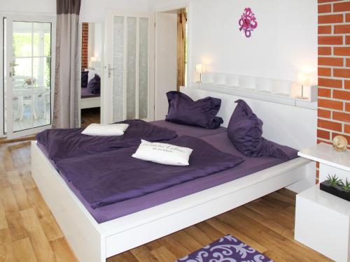 a bedroom with a large bed with purple sheets and pillows at Holiday Home Alexorella by Interhome in Godern