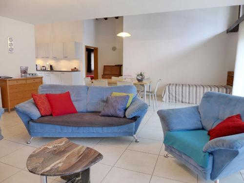 ein Wohnzimmer mit einem blauen Sofa und einem Tisch in der Unterkunft Apartment von Allmen by Interhome in Wilderswil