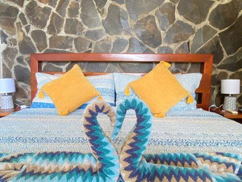 a bed with two crocheted towels on it at Casa Libertinn in Manuel Antonio