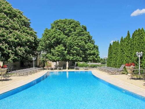 a large swimming pool with chairs and trees at Apartment Marjolaine - LCC127 by Interhome in Bauduen