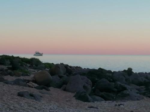 a boat in the water with a rocky beach at Luna e Mare in Cala Gonone