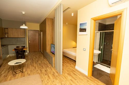 a small room with a bed and a bathroom at Porta Apartament in Vlorë