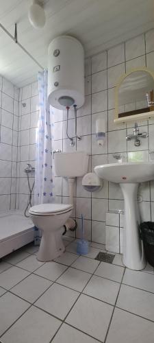 a bathroom with a toilet and a sink and a tub at Guest House Tiha noć in Žabljak