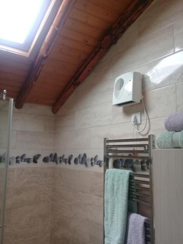 ein Badezimmer mit Dusche, Handtüchern und Ventilator in der Unterkunft Agua Azul poolside rest a luxurious rural woodland idyll in Cabeçadas