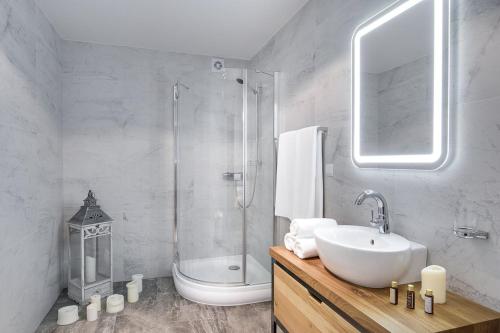 a white bathroom with a sink and a shower at Samosia in Karpacz