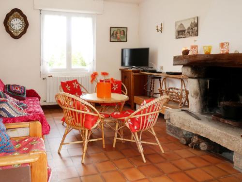 un salon avec une table et des chaises et une cheminée dans l'établissement Holiday Home Les Genêts by Interhome, à Plomeur