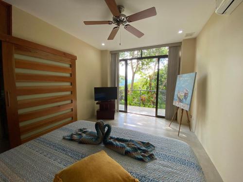 a bedroom with a bed with a ceiling fan at Casa Libertinn in Manuel Antonio