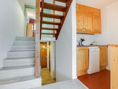 Un escalier mène à la cuisine d'une maison. dans l'établissement Apartment Brelin La Challe 635 by Interhome, aux Menuires
