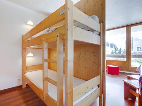 a bunk bed in a room with a large window at Apartment Chavière-5 by Interhome in Les Menuires