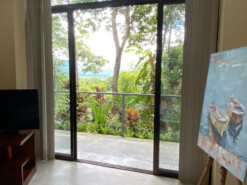 a room with a large glass door leading to a balcony at Casa Libertinn in Manuel Antonio