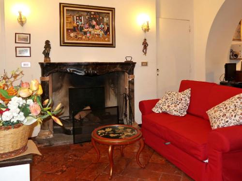 ドンゴにあるApartment Il Giardino by Interhomeのリビングルーム(赤いソファ、暖炉付)