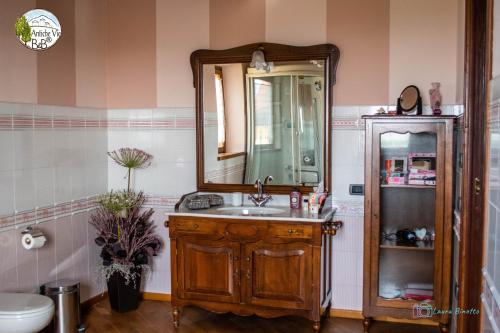a bathroom with a sink and a mirror at Antiche Vie B&B in Serramazzoni