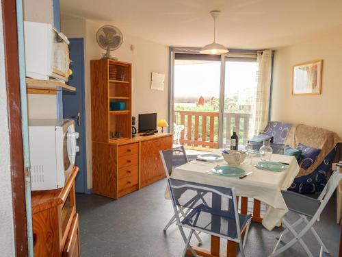 une cuisine et un salon avec une table et des chaises dans l'établissement Apartment Gruissan Plage by Interhome, à Gruissan