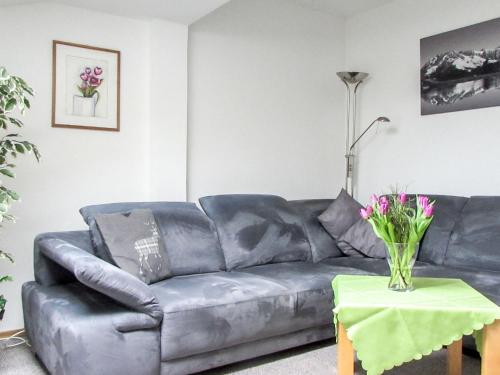 Una sala de estar con un sofá y una mesa con flores. en Apartment Haus Zimmermann by Interhome, en Innsbruck