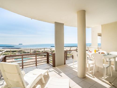 uma varanda com mesa e cadeiras e a praia em Apartment Le Sunset-Cap Sud-7 by Interhome em Cap d'Agde