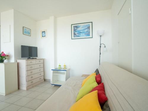 a living room with a couch and a tv at Apartment Le Sunset-Cap Sud-7 by Interhome in Cap d'Agde