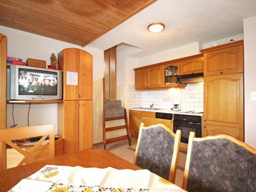 a kitchen with a table and a television in a room at Apartment Untererhof-1 by Interhome in Pankrazberg
