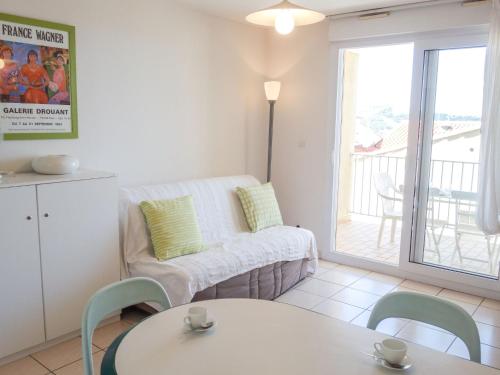 uma sala de estar com um sofá, uma mesa e cadeiras em Apartment Thalacap by Interhome em Banyuls-sur-Mer