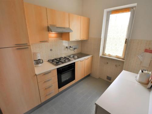 a kitchen with wooden cabinets and a stove top oven at Apartment Villa Laura-3 by Interhome in Crone
