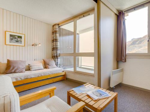 un salon avec un canapé et une fenêtre dans l'établissement Apartment Origanes 324 by Interhome, aux Menuires