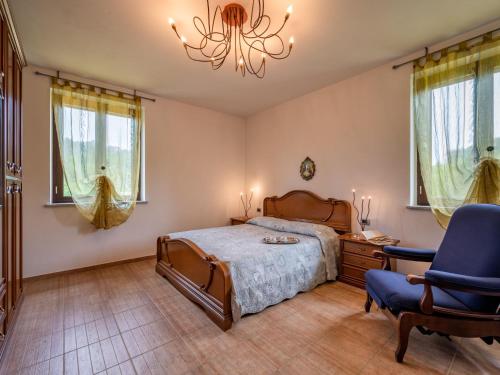 a bedroom with a bed and a chair and a chandelier at Holiday Home Casa Nocciola by Interhome in Ferrere
