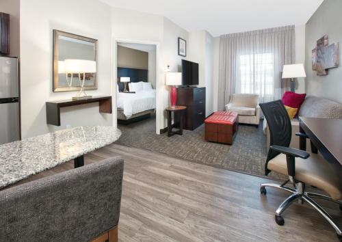 a hotel room with a bedroom and a living room at Staybridge Suites Plano - Richardson Area by IHG in Plano