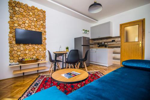 a living room with a couch and a table and a kitchen at Apartment Sunčana dolina in Zlatibor