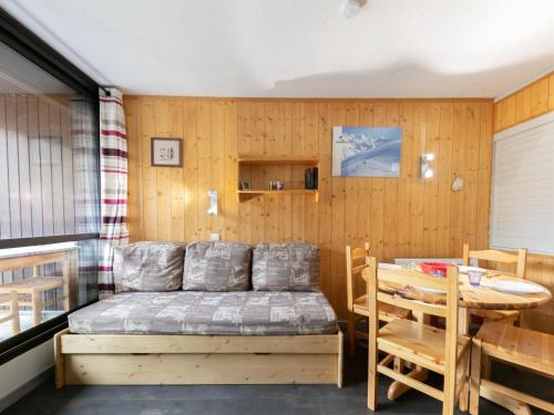 レ・メニュアールにあるApartment Les Soldanelles by Interhomeのベッドルーム1室(ベッド1台、テーブル、テーブル、椅子付)