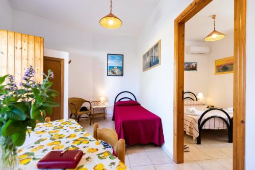 a room with a table and a room with two beds at HibiscusUno Tropea Residence in Tropea