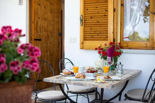 una mesa con desayuno y flores en HibiscusUno Tropea Residence, en Tropea