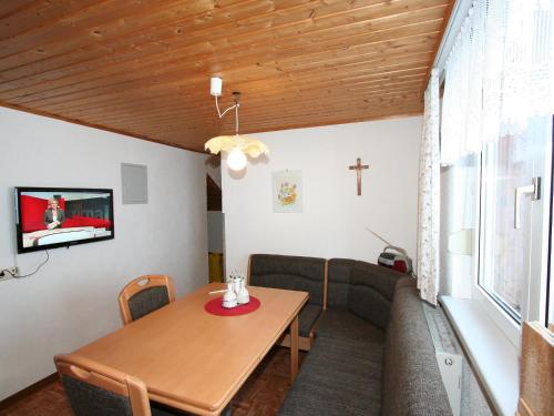 een eetkamer met een tafel en een kruis aan de muur bij Apartment Mangeng-2 by Interhome in Bartholomäberg