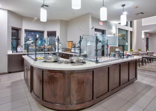 a large kitchen with a counter with food on it at Staybridge Suites Plano - Richardson Area by IHG in Plano