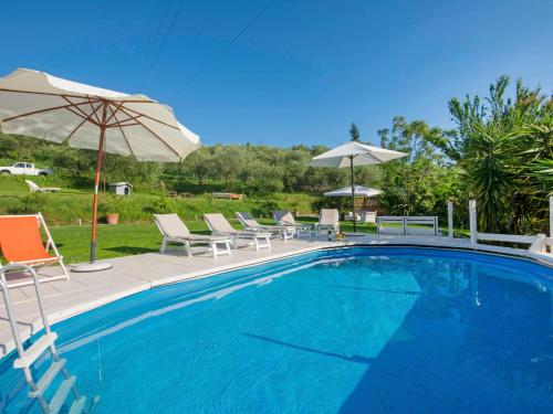 a swimming pool with chairs and an umbrella at Holiday Home Olivo by Interhome in Massarosa