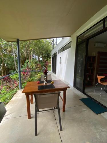 a wooden table and a chair on a patio at Casa Libertinn in Manuel Antonio